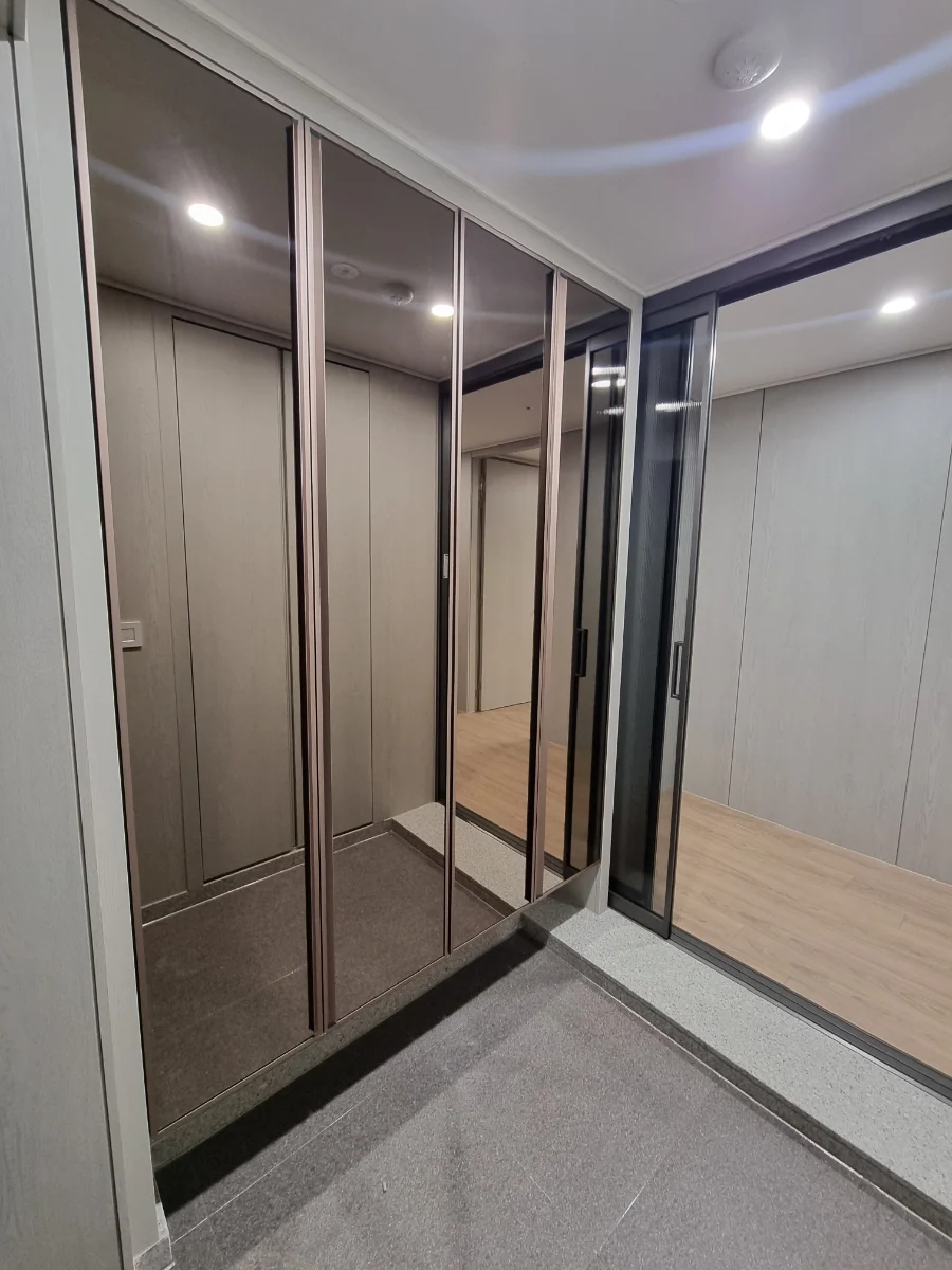 이지유리 실제 시공: 브론즈 거울과 로즈골드 바를 조합한 신발장 문